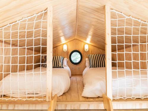 a bedroom with two bunk beds and a window at HolaCamp Sitges Garrofer in Sitges