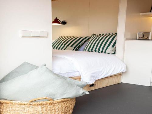 a small bedroom with a bed and a basket at HolaCamp Sitges Garrofer in Sitges
