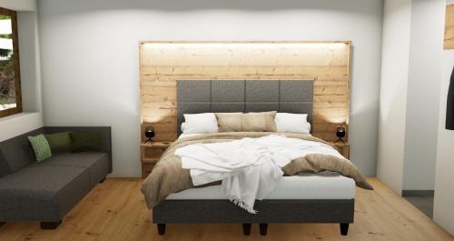 a bedroom with a large bed and a couch at Apart Hotel Alpenhof Werfenweng in Werfenweng