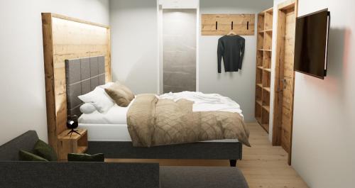 a bedroom with a bed and a tv on a wall at Apart Hotel Alpenhof Werfenweng in Werfenweng