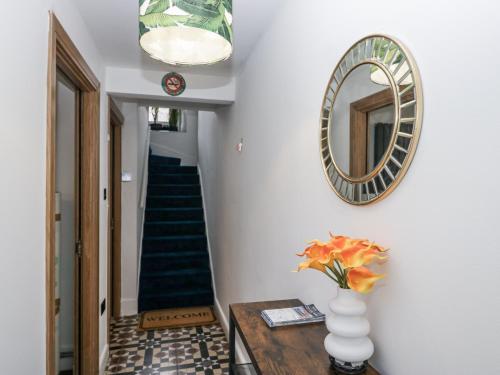 a hallway with a vase on a table and a mirror at Aspen Boutique in Windermere