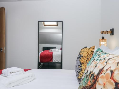 a bedroom with two beds and a mirror at Aspen Boutique in Windermere