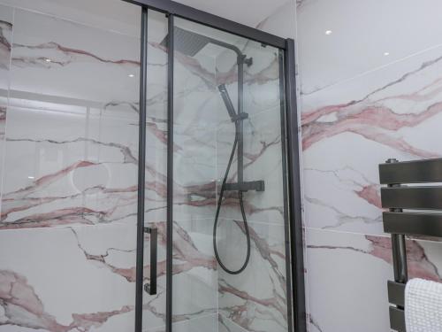 a shower in a bathroom with marble walls at Aspen Boutique in Windermere