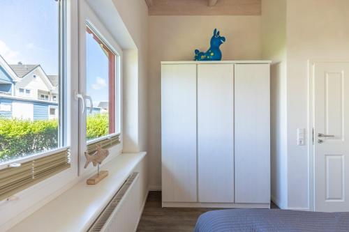 a bedroom with a white cabinet and a window at Ferienhaus - Sylt in Dagebüll