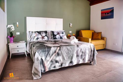 a bedroom with a large bed and a chair at La maison di Lea in Gaeta