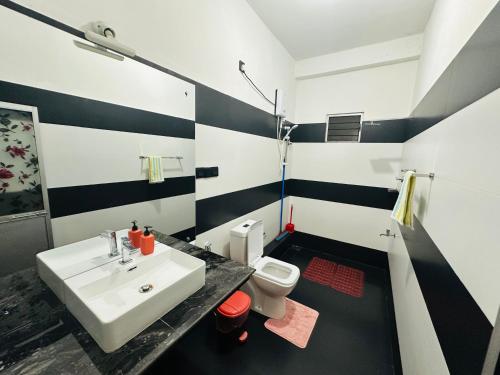 a black and white bathroom with a sink and a toilet at Ambuluwawa View Inn in Gampola