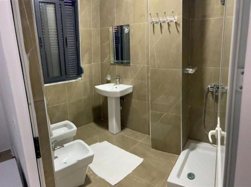 a bathroom with a toilet and a sink and a shower at Hotel Italia in Golem
