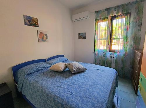 a bedroom with a blue bed with a pillow on it at Villa Angelina in Gaeta