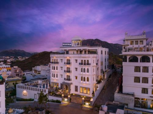 a large white building in a city at night at Maan Vilas - A Boutique Hotel Udaipur in Udaipur