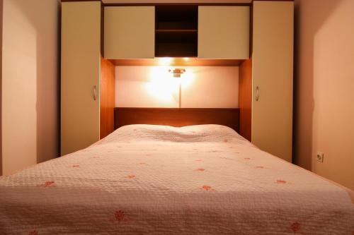 a small bedroom with a bed with a headboard at Apartments Milovan in Fažana