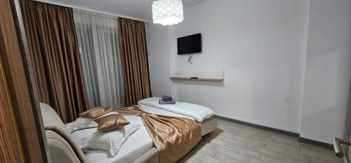 a hotel room with two beds and a television at Mamaia Nord Promenada - Beach Pool si Spa Resort langa plaja in Mamaia Nord