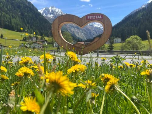 a heart sign in a field of yellow flowers at Gschlössle Ferienwohnungen in Jerzens