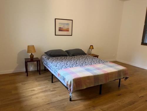 a bed in a room with two night stands and two lamps at Le Dorat Bright & Quiet in Le Dorat