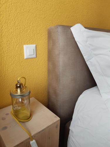 a jar of honey on a night stand next to a bed at Les logis de l'horloger in La Chaux-de-Fonds