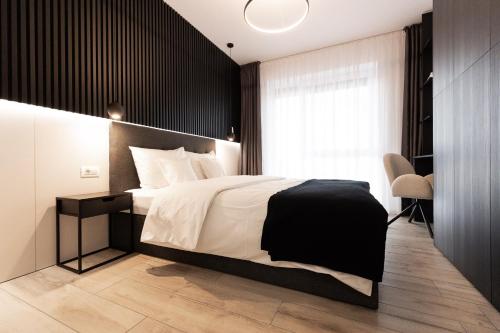 a bedroom with a large bed with a black wall at Royalton Urbana in Oradea