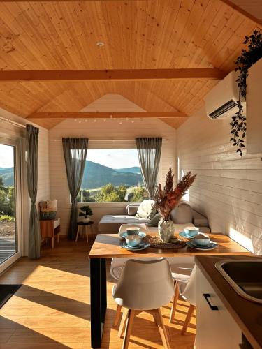 a kitchen and living room with a table and chairs at Horyzont Spokoju in Podobin