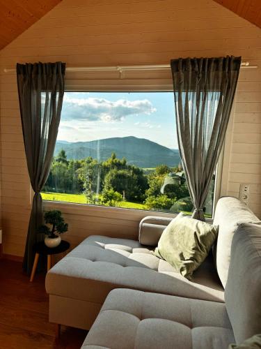 a living room with a couch and a large window at Horyzont Spokoju in Podobin