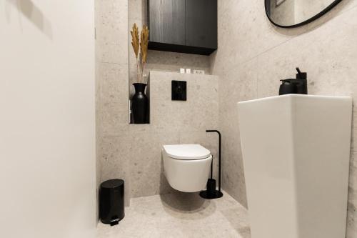 a bathroom with a white toilet in a room at Royalton Urbana in Oradea