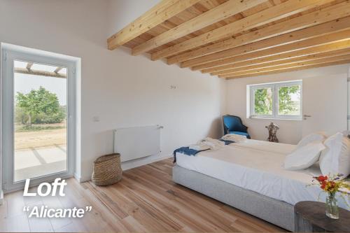 a bedroom with a bed and a large window at Alojamentos Plansel - No Coração das Vinhas do Alentejo in Montemor-o-Novo