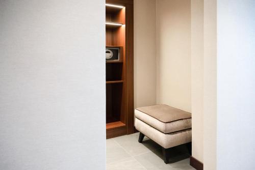 a small room with a chair and a stool at Hilton Milan in Milan
