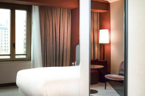 a hotel room with a tub and a window at Hilton Milan in Milan