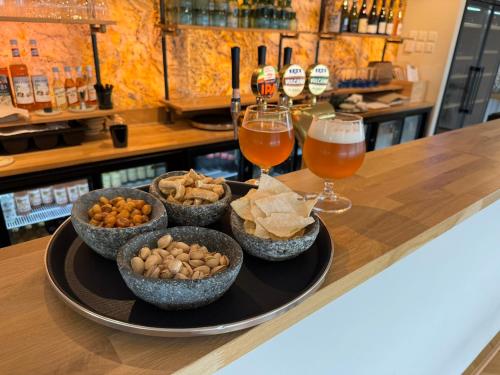 a tray with bowls of food and glasses of beer at Bramslev Bakker Naturhotel in Hobro