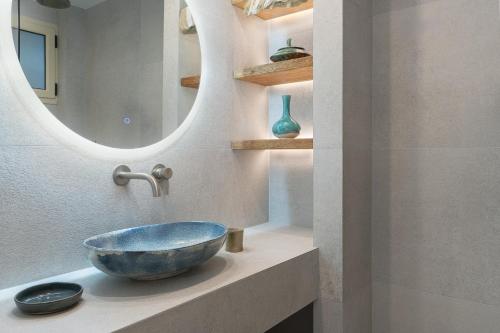 baño con un bol en una encimera con espejo en Lemonia Accommodations, en Lithakia