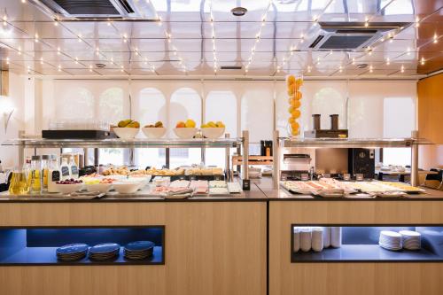 a buffet line with plates of food in a restaurant at Civis Jaime I in Castellón de la Plana