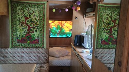 Una autocaravana con dos cortinas y una cama dentro. en Caravane, en Saligny-sur-Roudon