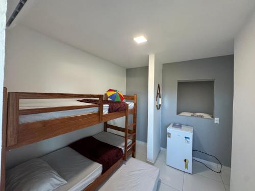 two bunk beds in a room with a small refrigerator at Maraki Suítes Maragogi 150M do Mar in Maragogi