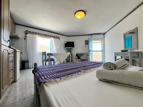 ein Schlafzimmer mit einem großen Bett und eine Küche in der Unterkunft Koukida House in Donousa