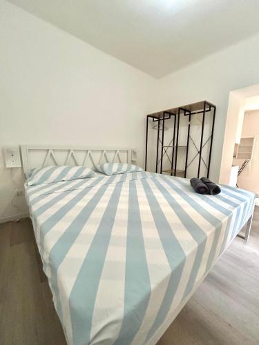 a bedroom with a large bed with blue and white stripes at Residence Zar 9 in Trieste