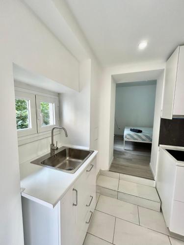 a kitchen with white cabinets and a sink at Residence Zar 9 in Trieste