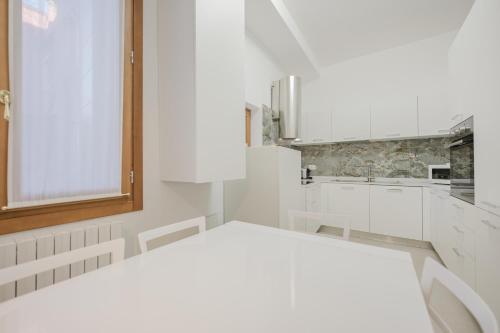 a white kitchen with white cabinets and a window at Santo Stefano Palace in Venice