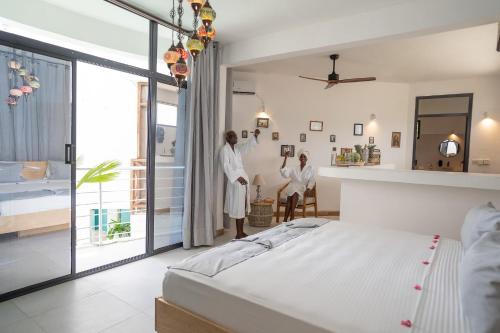 two women standing in a bedroom with a bed at ZAN Tropical Island in Bwejuu