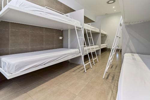 a room with two bunk beds and a staircase at The Book Factory Hostel by gaiarooms in Valladolid