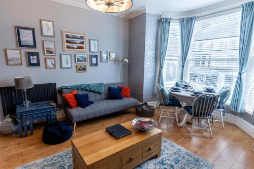 a living room with a couch and a table at ORME RISE - Beautiful first floor apartment in Llandudno