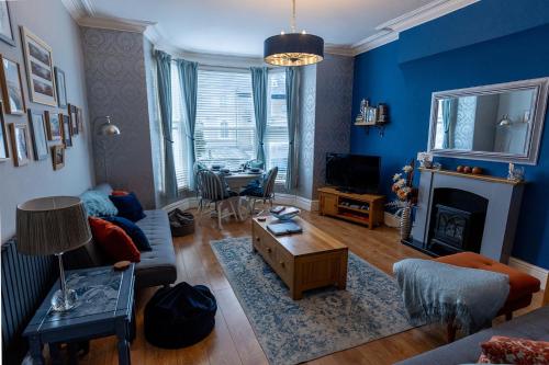 a living room with a couch and a table at ORME RISE - Beautiful first floor apartment in Llandudno