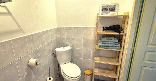 a bathroom with a toilet and towels on a shelf at Ruime vakantie accommodatie in rustige, landelijke omgeving in Seuzey