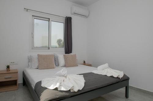 Un dormitorio con una cama con sábanas blancas y una ventana. en Elhasa Laganas Villa BY "ELITE", en Laganas