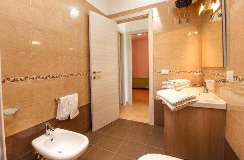 a bathroom with a sink and a toilet and a mirror at Family Suite Porto Vecchio in Lampedusa