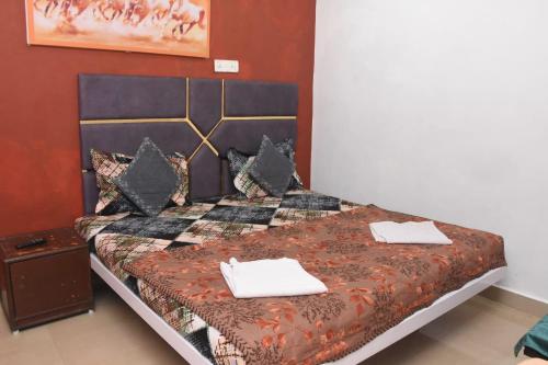 a bedroom with a bed with two towels on it at The Grand Bagicha Residency Matheran in Matheran