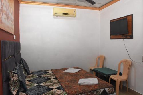 a room with a bed and a table and a tv at The Grand Bagicha Residency Matheran in Matheran