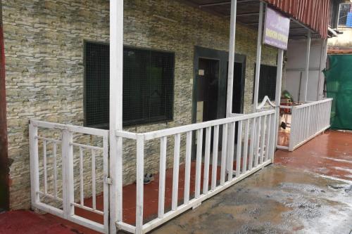 a white fence in front of a brick building at The Grand Bagicha Residency Matheran in Matheran