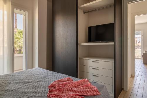 a bedroom with a bed with a tv on a shelf at Palladio13 in San Benedetto del Tronto