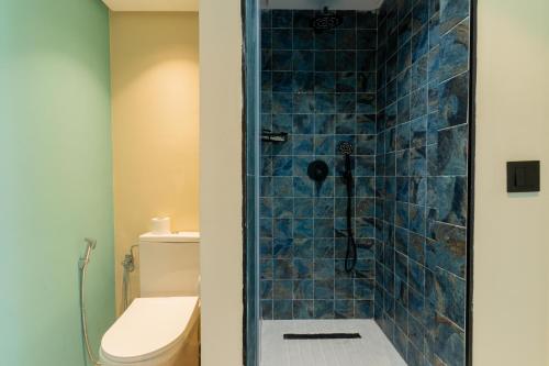 a bathroom with a blue tiled shower with a toilet at MIA Urban Agadir in Agadir