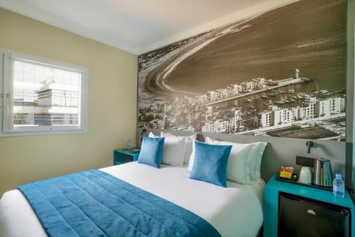 a bedroom with a bed with a painting on the wall at MIA Urban Agadir in Agadir