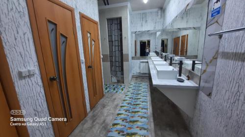 a bathroom with three sinks and a row of mirrors at Premium Hostel Atyrau in Atyraū
