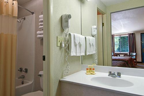 ein Bad mit einem Waschbecken und einem Spiegel in der Unterkunft Shayona Inn - Eden in Eden