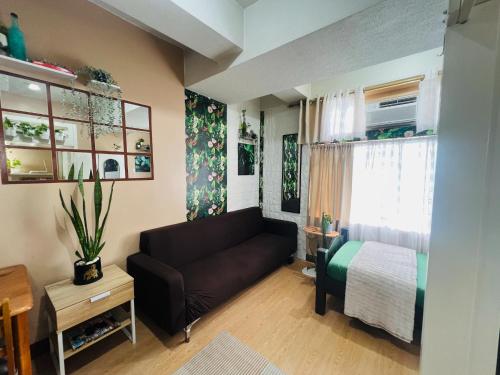 a living room with a couch and a bed at Casa Tagpuan in Manhattan ParkWay in Manila